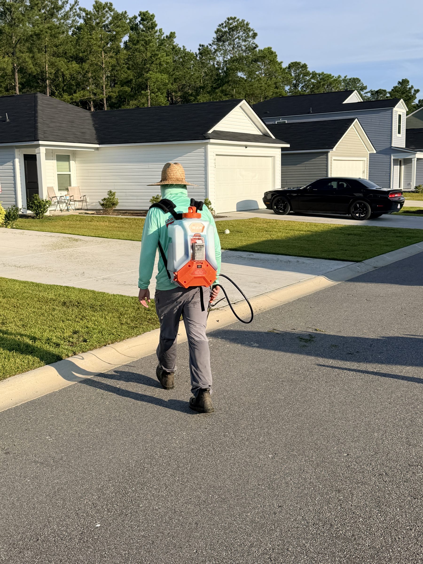 Crew member blowing off a driveway during cleanup