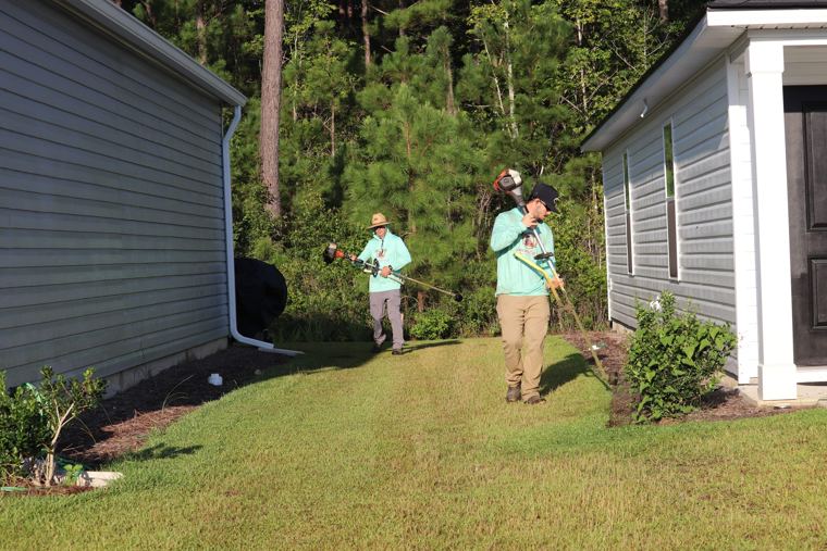 Crew trimming along a home